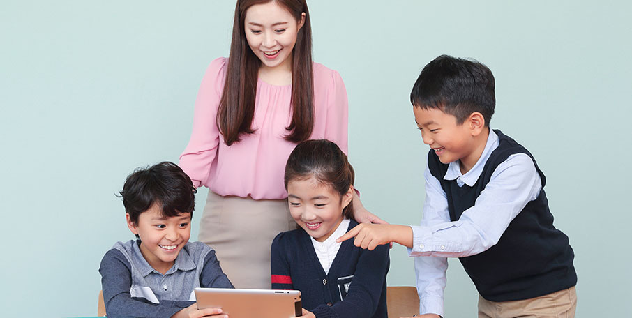 SEED CLASS 아이들과 선생님이 태블릿 PC를 보며 웃는 모습